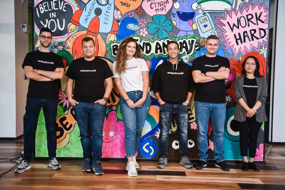 Une équipe variée collabore autour de stratégies de marketing digital à une table, avec des ordinateurs portables et des tablettes.